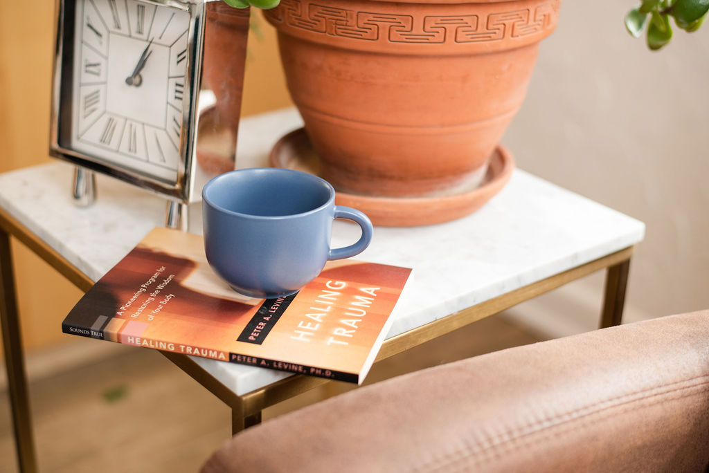 Book called Healing Trauma on a coffee table with a mug on top
