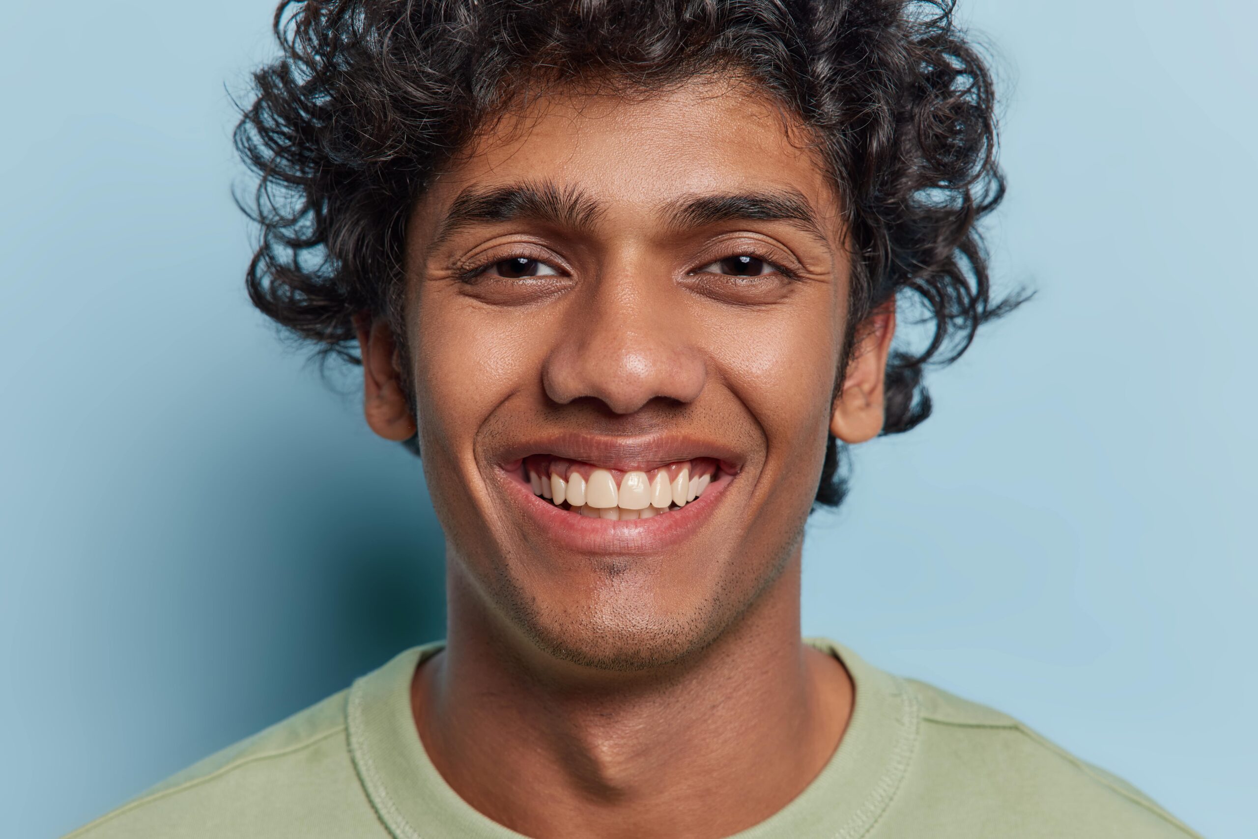 Up close of young man in front of a blue wall